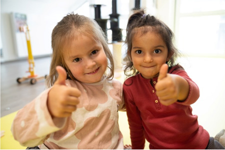 2 Kitakinder zeigen Daumen hoch.
