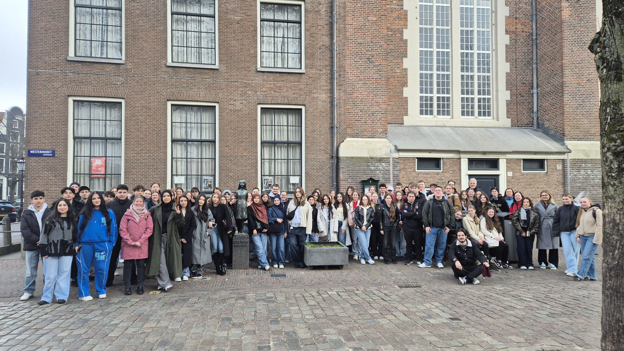 Gruppenbild vor der Anne Frank-Statue am Westermarkt in Amsterdam