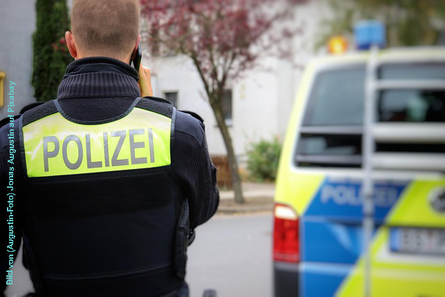 Polizist von hinten mit Aufschrift auf Rücken Polizei.